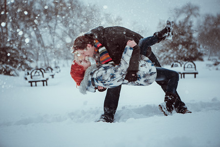 快乐的年轻夫妇，在冬季公园户外有 fun.family。爱的吻