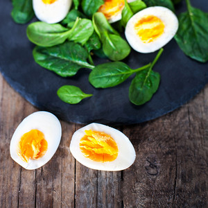 蛋黄摄影照片_菠菜叶和煮熟的鸡蛋