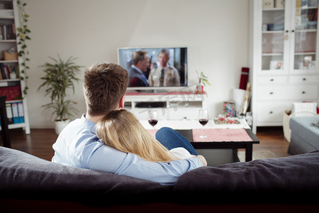 tv摄影照片_couple enjoying themselves and watching tv on the sofa