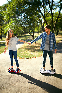 年轻的男人和女人骑在公园里飞。内容的技术。一个新的运动