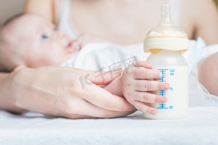 孕婴摄影照片_Baby holding a baby bottle with breast milk
