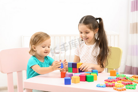 学习摄影照片_Cute girl playing with little sister at home