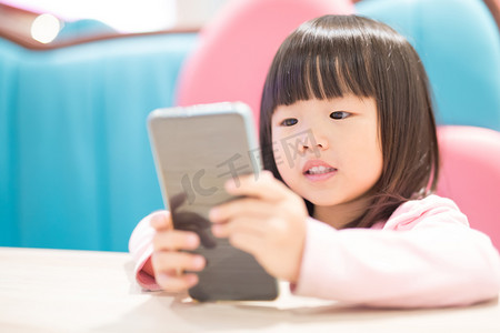 平板游戏摄影照片_使用智能手机的孩子.