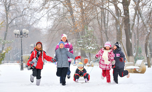 dzieci摄影照片_群儿童和母亲在冬天的时候在雪地上玩