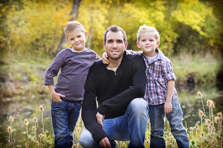 儿子给父亲摄影照片_一位父亲和他两个儿子的室外肖像