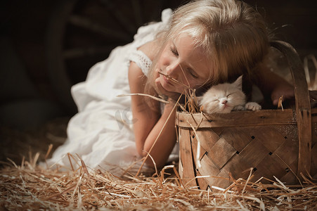 一只小猫在干草上的女孩