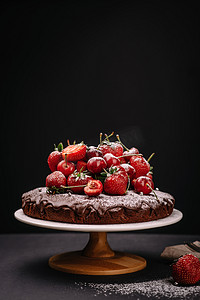 巧克力蛋糕摄影照片_托斯卡纳的巧克力蛋糕，草莓和樱桃