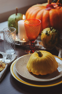 感恩节美食背景摄影照片_秋季传统表设置为感恩节或万圣节，与蜡烛南瓜.