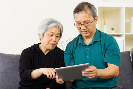 亚裔夫妇一起在家里使用平板电脑