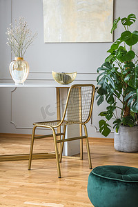 金色地产建筑摄影照片_在别致的客厅小餐桌上的金色椅子