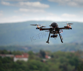 hexacopter摄影照片_带着照相机在空中飞行的无人飞机 