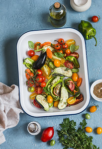 原料为午餐-新鲜剁碎蔬菜中把平底锅放在蓝色的背景，顶视图。健康的素食食品