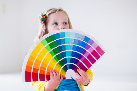 小小设计师摄影照片_选择墙漆颜色的小女孩