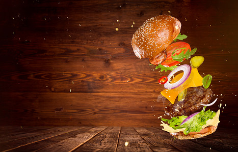红色复古背景摄影照片_大美味的汉堡与飞行成分.