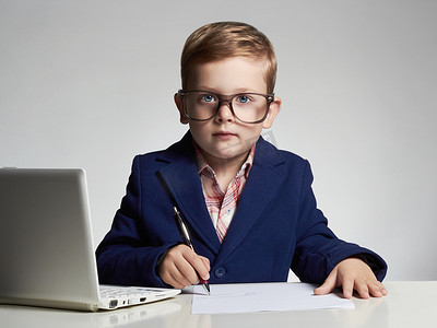 使用笔记本电脑的年轻商人。有趣的孩子，在眼镜