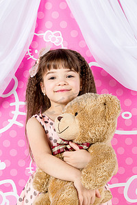 她笑的好开心摄影照片_小女孩抱着玩具熊