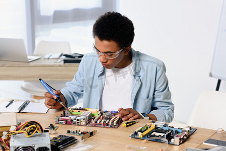 美国黑人青少年在家焊接电脑电路