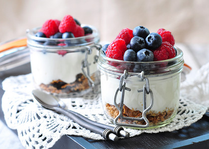 organic摄影照片_homemade granola with fresh yougurt, blueberries, raspberries, raisins and organic agave nectar. Healthy Breakfast