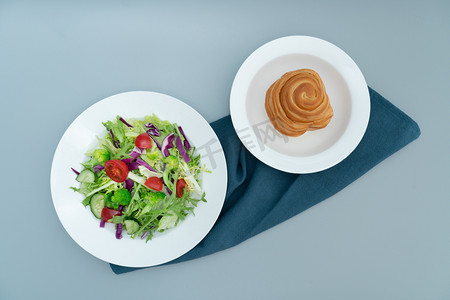 绿色极简风格摄影照片_一盘健康可口的沙拉和面包一盘美味健康的绿色蔬菜沙拉.