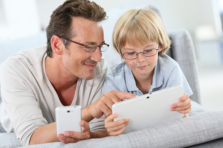 父亲和儿子与平板电脑和智能手机