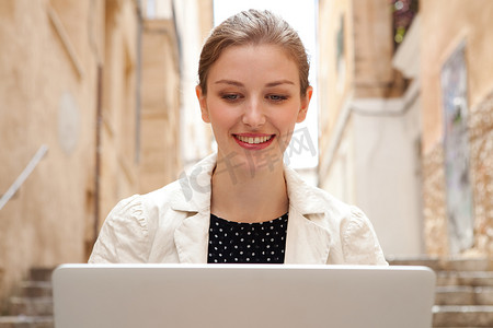 校园科技摄影照片_business woman using a laptop computer outdoors