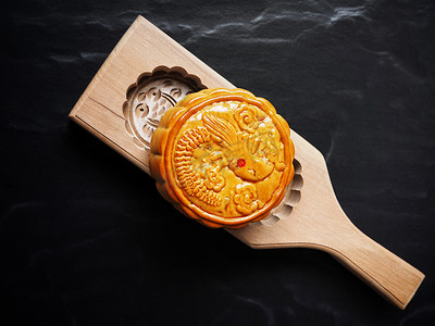 传统节日中国月饼木板上的黑石背景