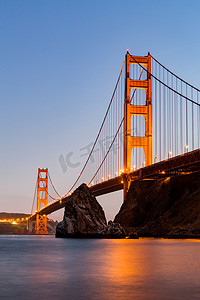 亮金色建筑摄影照片_旧金山金门大桥在日落
