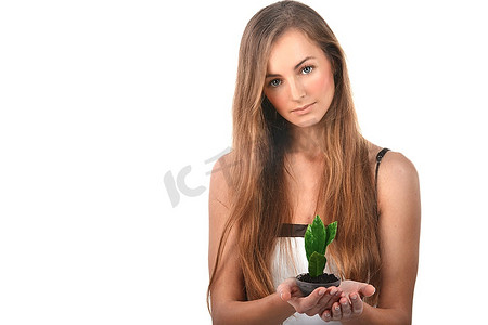 美丽的年轻女子，手心里长着绿色的树芽