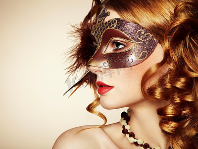 一位戴着棕色神秘威尼斯面具的年轻漂亮女子。时尚写真