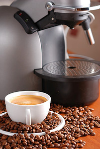 咖啡机和一杯浓缩咖啡。洒出了咖啡豆。