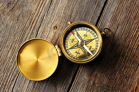 古董黄铜指南针在木背景