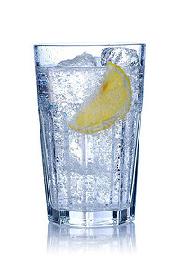 水杯加冰块摄影照片_加冰块和柠檬的水杯，白色。柔和的倒影。