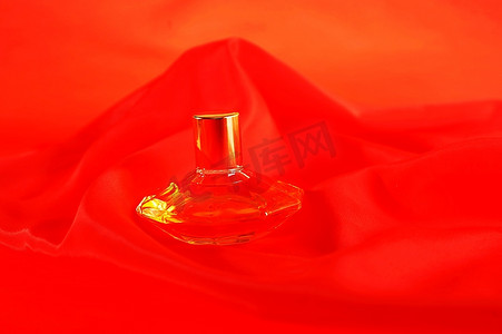 特写商品摄影照片_一瓶香水，隔离在红色特写上