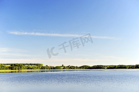 全景树林摄影照片_平静的湖水，对岸的树林和蔚蓝的天空。景观