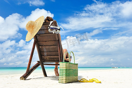 女孩在一个热带海滩与帽子