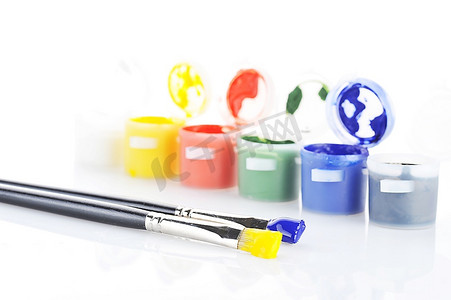 白色背景上孤立的水粉油漆罐和画笔