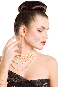 一个年轻的女子，深色皮肤，胸部周围有一条花边，戴着珍珠项链