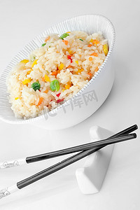 一碗蔬菜炒饭和筷子。中式烹饪