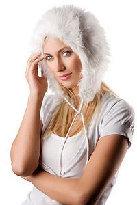 关闭一个年轻美丽的模型的画象在白色冬天礼服与一顶好的毛皮帽子