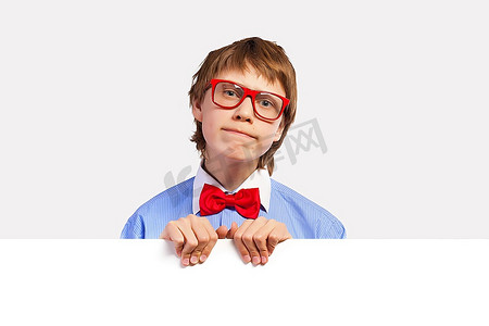 红白色海报摄影照片_戴红眼镜的小学生手持白色方块