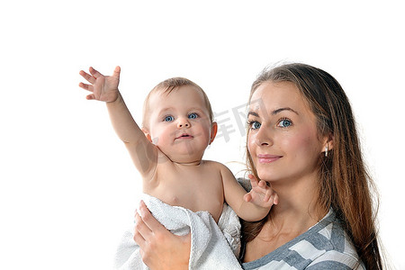 拥抱孩子摄影照片_母亲在家中用白毛巾抱着可爱的婴儿