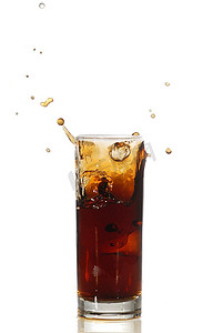 装冰块的杯子摄影照片_冰块落入可乐中，溅起水花