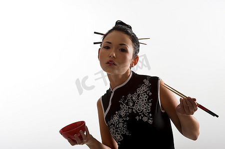 红色的筷子摄影照片_美丽的亚洲女孩在japanes衣服吃东方食物从一个红色的杯子使用