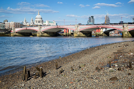 急性心绞痛摄影照片_退潮的泰晤士河和伦敦城市的天际线，包括圣保罗和急性；S大教堂