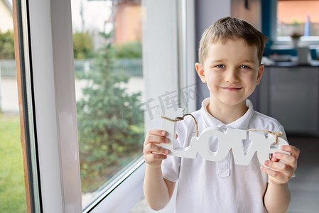 快乐家庭海报摄影照片_快乐的小男孩，手持一木的题词，与