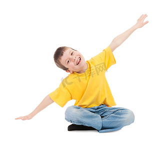 坐飞机的儿童摄影照片_黄色 t 恤的男孩模拟飞行