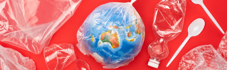 地球温度摄影照片_在红色的全球暖化概念下，用塑料袋装着垃圾的全球全景