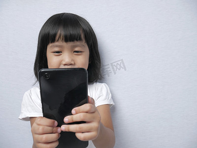 儿童韩文摄影照片_带着智能手机小玩意的小女孩