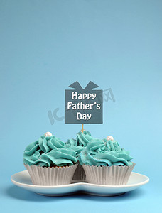 爱情甜点摄影照片_快乐的父亲一天特别对待蓝色和白色美丽装饰的蛋糕蓝色背景上的消息