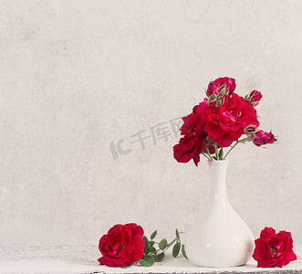 花瓶古董摄影照片_花瓶里有一束红玫瑰